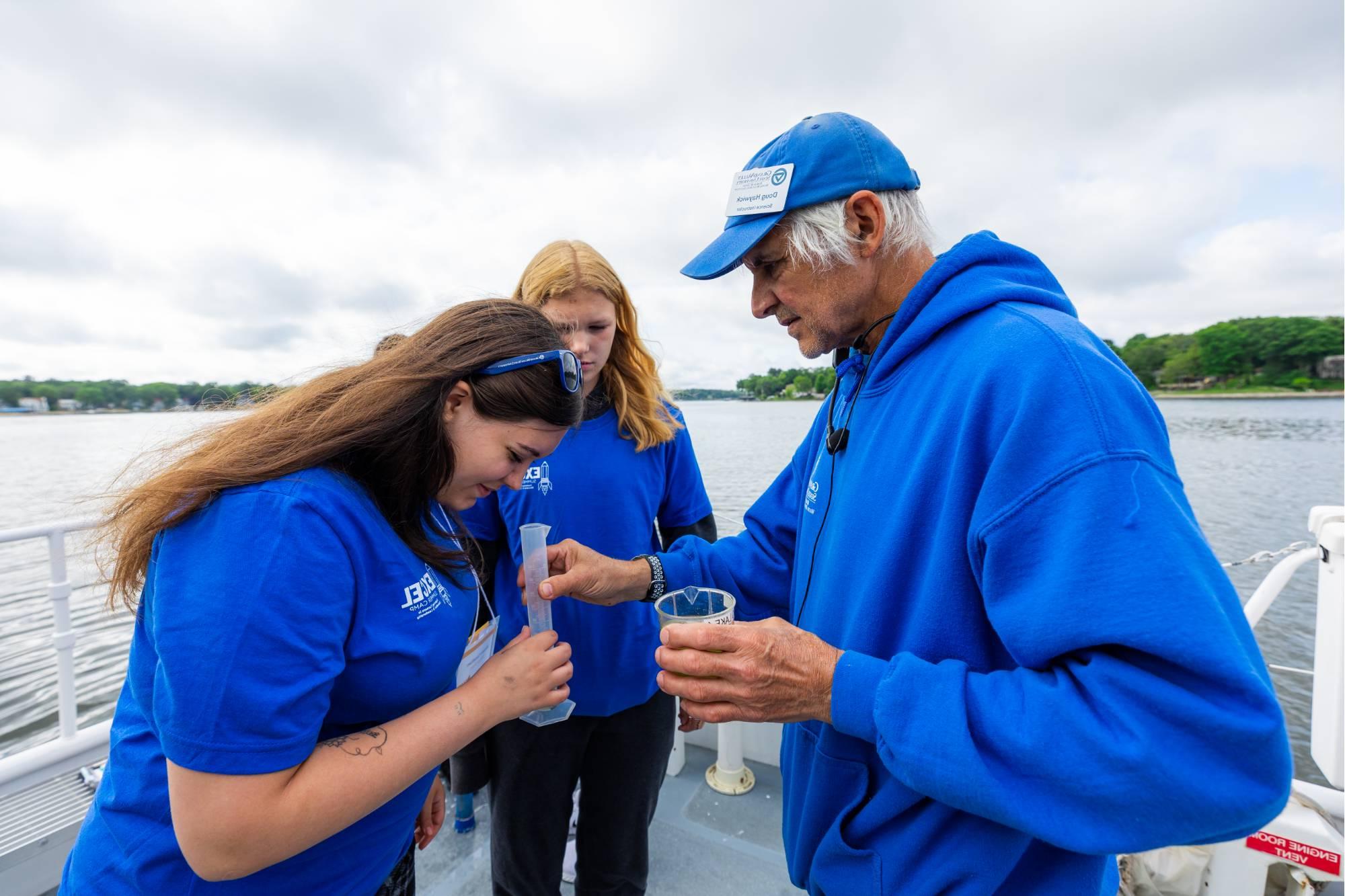 AWRI vessel instructor Doug Haywick assists students with a plankton density test onboard the D.J. Angus